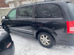 2009 Chrysler Town & Country minivan with 153k miles parked in snow, featuring a backup camera and functional windows.