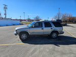 1999 Chevrolet Blazer parked in an outdoor lot, featuring LED headlights and a V6 Vortec engine.
