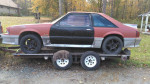 1987 Ford Mustang GT parts car with minimal rust on a trailer, ideal for drag racing projects.