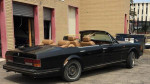 1981 Rolls-Royce Corniche custom convertible parked outside, showcasing its unique design and luxurious beige interior.