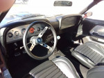Interior view of a 1969 Ford Mustang Mach 1 featuring vintage gauges and black seating.
