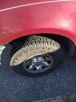 Close-up of the tire and wheel of a Ford F250 truck, highlighting its rugged design and tread pattern.
