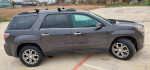 2013 GMC Acadia SLT in gray with roof racks, parked on a lot, showcasing a clean and sleek exterior