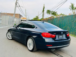 2014 BMW 4 Series 428i xDrive Coupe in dark blue with alloy wheels, parked on a street