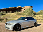 2011 BMW 328i E90 in titanium silver parked in a scenic outdoor setting