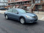 2010 Nissan Altima Hybrid sedan in gray with 122K miles, parked on a driveway.