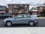 Side view of a 2010 Nissan Altima Hybrid sedan in excellent condition with low mileage.