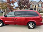 2005 Chrysler Town & Country minivan parked in front of a house with trees in autumn colors