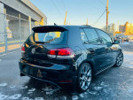 2013 Volkswagen GTI Driver's Edition, black, alloy wheels, parked with fence in background.