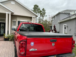 Red 2008 Dodge RAM 1500 Big Horn edition parked in front of a house, showcasing bed cover and rear view.