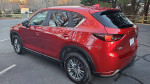 2017 Mazda CX-5 SUV in red, showcasing its sleek design and well-maintained condition, parked on a road.