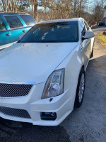 White Cadillac CTS sedan with a slight bumper modification and clean interior, showing signs of performance.