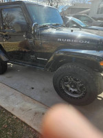 2012 Jeep Rubicon with new tires, steel bumpers, and off-road accessories parked outdoors