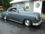 1950 Chevrolet 2-door hardtop with custom features and smooth idle, parked beside a garage