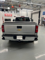 Rear view of a clean 2015 Chevrolet Silverado 1500, equipped with factory plow package and hitch.