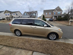 2011 Toyota Sienna XLE in gold parked in a residential area, featuring navigation and JBL audio.