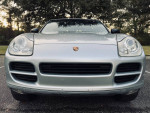 Front view of a 2005 Porsche Cayenne S in Reflex Silver, showcasing its sleek design and headlights.