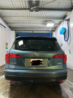 Rear view of a 2017 Honda Pilot EX-L parked at a car wash, showcasing its sleek design.
