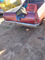 1968 El Camino with body work needed, parked with jeans and items in the truck bed, ideal project car for enthusiasts.