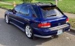 2001 Subaru Impreza in blue, showcasing its sporty rear design and new rims, great for daily driving.