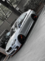 2011 BMW 5 Series 528i in Titanium Silver Metallic parked, featuring M5 exterior kit and black wheels.