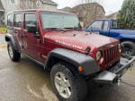 2008 Jeep Wrangler Rubicon 4WD in dark red, featured with clean body, 98,000 miles, parked in a driveway.