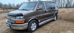 2004 Chevrolet Express 1500 AWD van in a grassy area, featuring leather seats and a power folding rear bench.