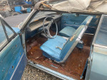 Interior view of a 1963 Chevrolet Impala Convertible showing blue seats and minor rust details.
