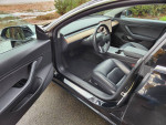 Interior of a 2018 Tesla Model 3, featuring sleek design and leather seats, door opened.