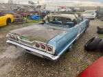 1963 Chevrolet Impala Convertible with minor rust, parked in a yard, showcasing its classic design.