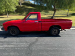 1983 Toyota Pickup in red, single owner, great condition with recent repairs, parked on a street.
