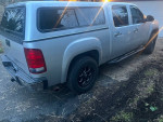 2012 GMC Sierra 1500 SLT 4WD truck parked, featuring a silver exterior and aftermarket tires.