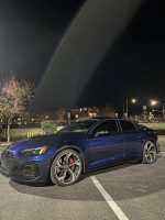 2021 Audi RS 5 Sportback in blue parked at night, showcasing its sleek design and luxury features.