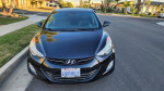 Front view of a 2013 Hyundai Elantra Limited sedan in black color, parked in a residential area.