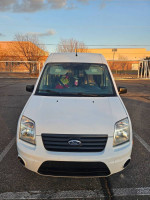 Front view of a white Ford van ideal for contractors and camping, showcasing its spacious interior and utility.