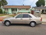Side view of a well-maintained Mercedes-Benz C280 in a residential area, showcasing its clean exterior and stylish design.