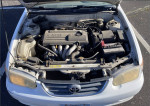 Engine compartment of a 2001 Toyota Corolla CE with VVT-i system and reliable mechanical components.