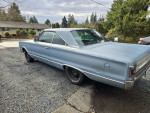 1967 Plymouth Satellite classic car, light blue, parked in driveway, showcasing sleek design and style.