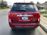 Rear view of a red 2010 Chevrolet Equinox LT parked on a residential street.