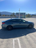 Side view of a 2016 Hyundai Sonata SE parked in a sunny area with mountains in the background.