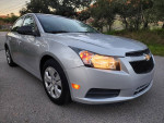 2014 Chevrolet Cruze LS sedan in silver parked on the road with a two-tone interior and clean exterior.