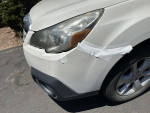 White 2013 Subaru Outback with minor damages, showing tape on front bumper.