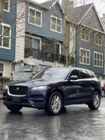 Blue Jaguar F-PACE parked in front of residential building, showcasing luxury design and features.