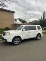 2014 Honda Pilot EX 4WD in white parked on the street, featuring leather interior and third-row seating.