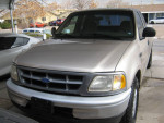 Front view of a well-maintained 1999 Ford F150 XL truck, silver color with low mileage and new tires.