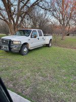 2004 Ford F350 Super Duty truck parked on grass, featuring leather seats and aftermarket exhaust.