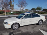 2004 Volvo S80 2.9 FWD sedan in white, showcasing its smooth ride and stylish design, parked on a sunny street.