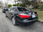2009 Hyundai Genesis sedan in black parked on the street with polished alloy wheels and tinted windows