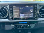 Interior dashboard of a 2021 Toyota Tacoma SR5 showing radio and climate controls.
