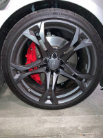 Close-up of a 2021 Chevrolet Camaro wheel with red brake calipers and sleek black rim design.